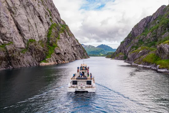 An electric catamaran sailing into Trollfjord in nice weather