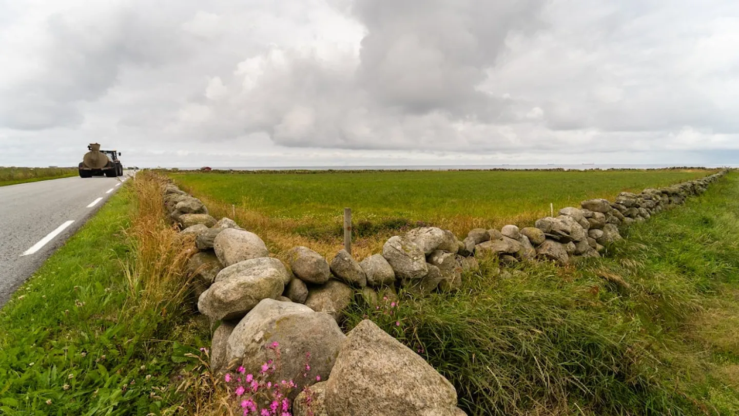 A tractor driving along the landscape of Jæren