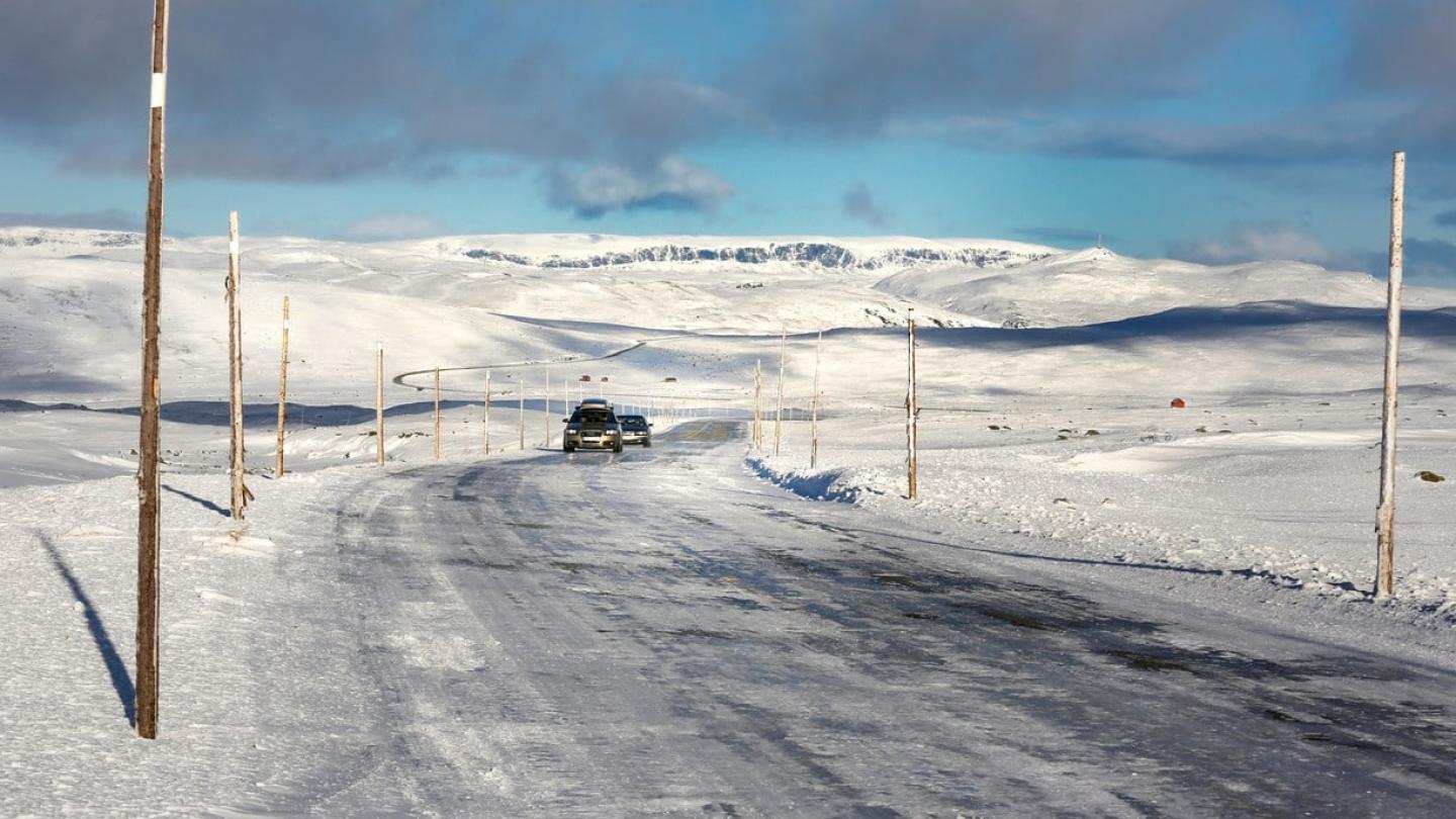 Cars driving in the snow over Hardangervidda