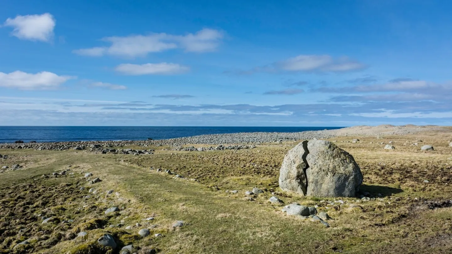 The view towards the water. A big rock in the middle foreground.