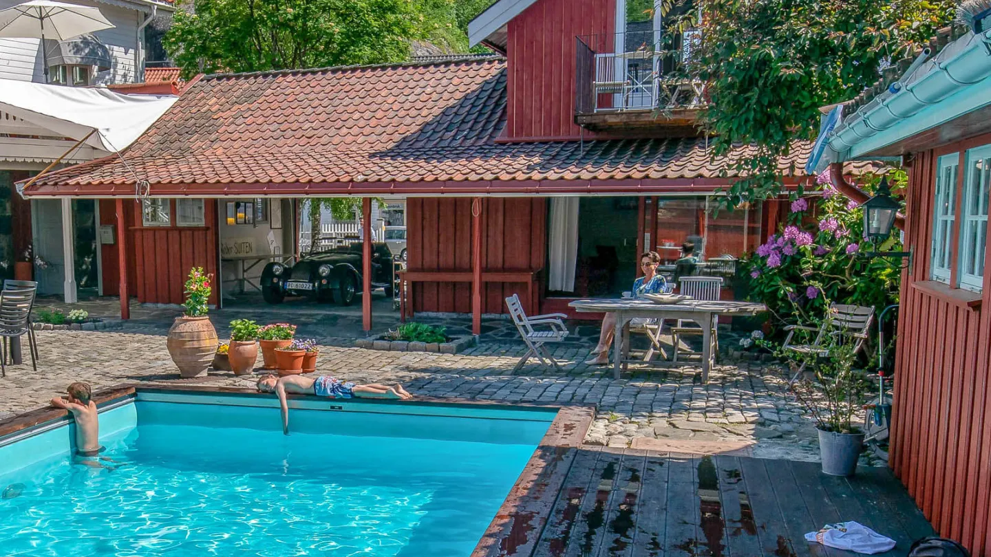 A view over the outdoor pool area at Det Lille Hotel in Risør. Sunny weather.