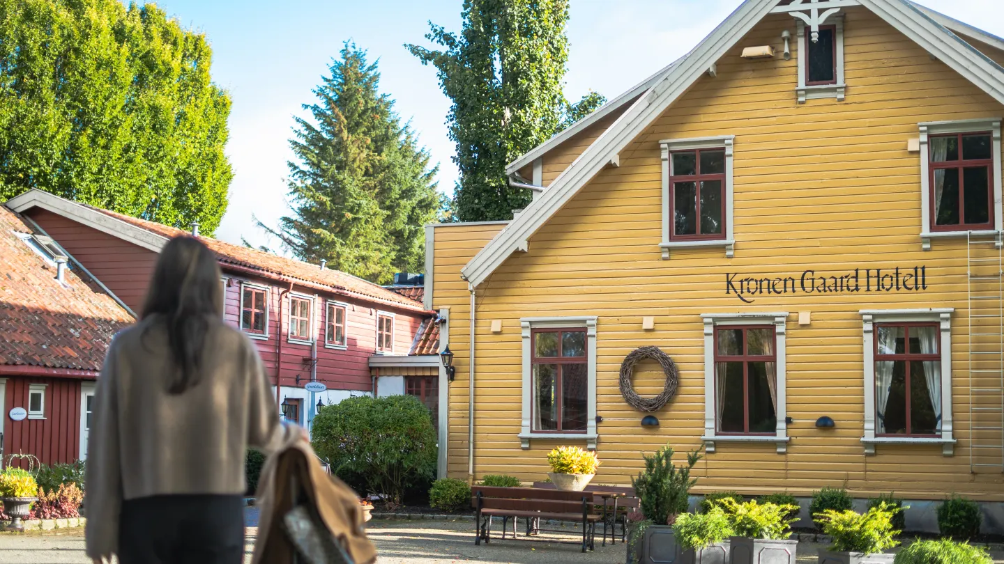 The back of a lady watching the exterior of Kronen Gaard Hotel