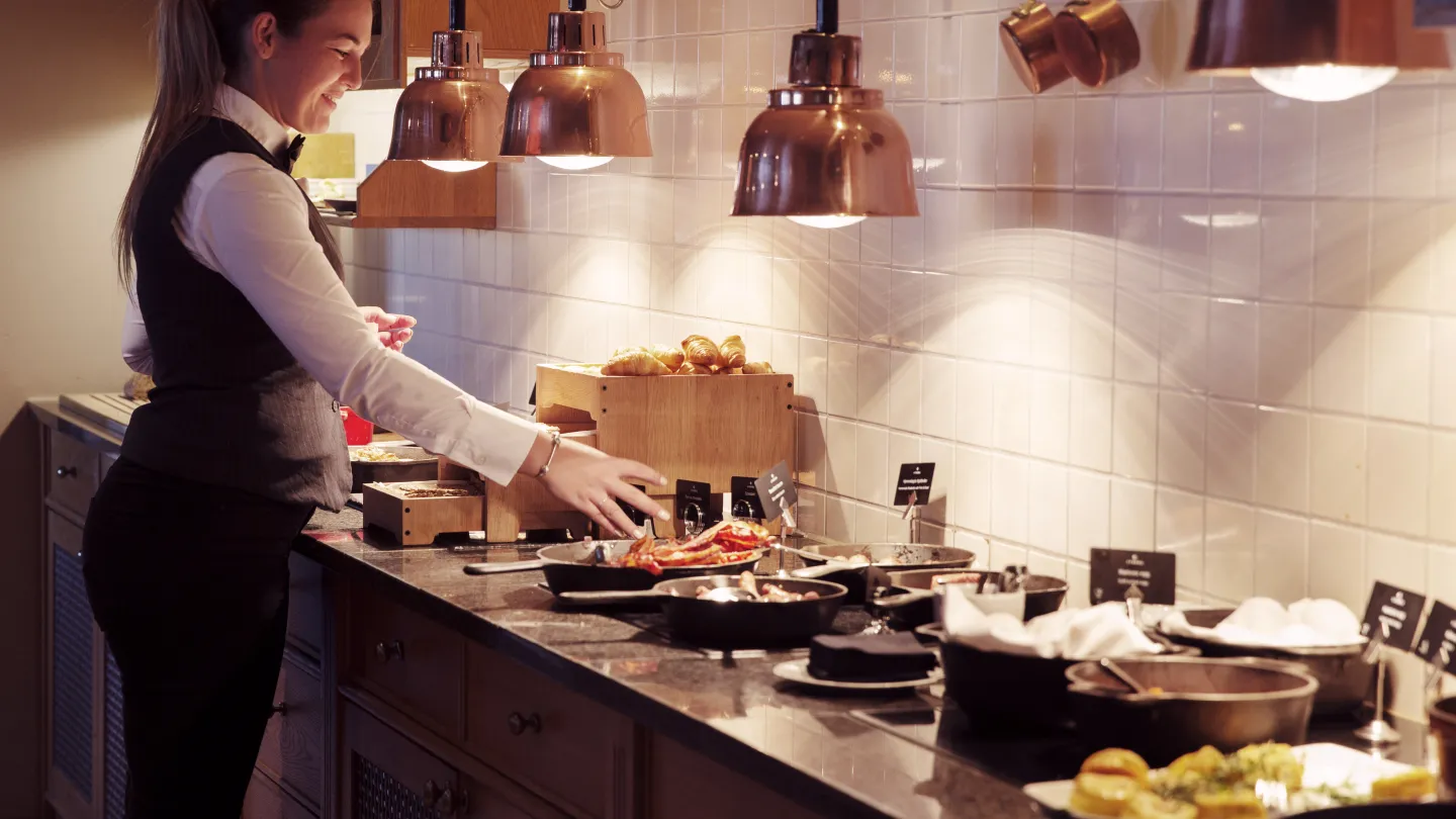 A server dishing up the buffet at Lysebu