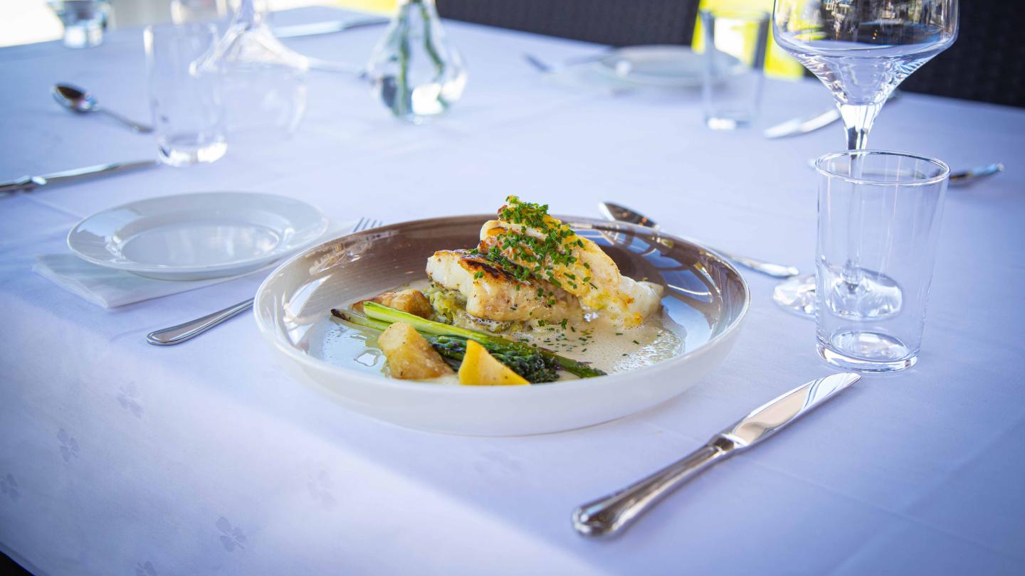 A fish dish served at a table with white tablecloth at Bekkjarvik Gjestgiveri
