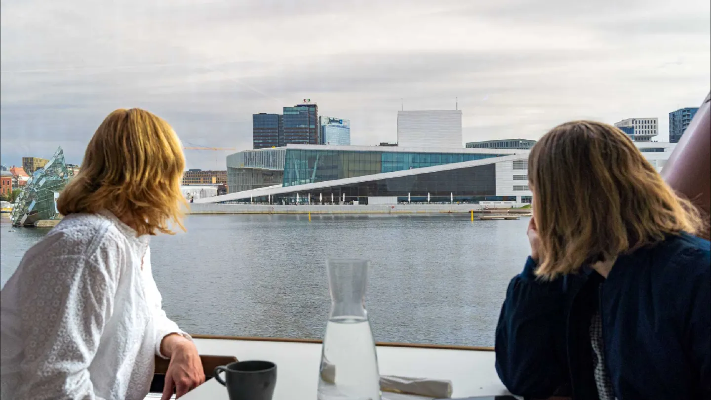 A couple watching over the Oslofjord towards the Oslo Opera House