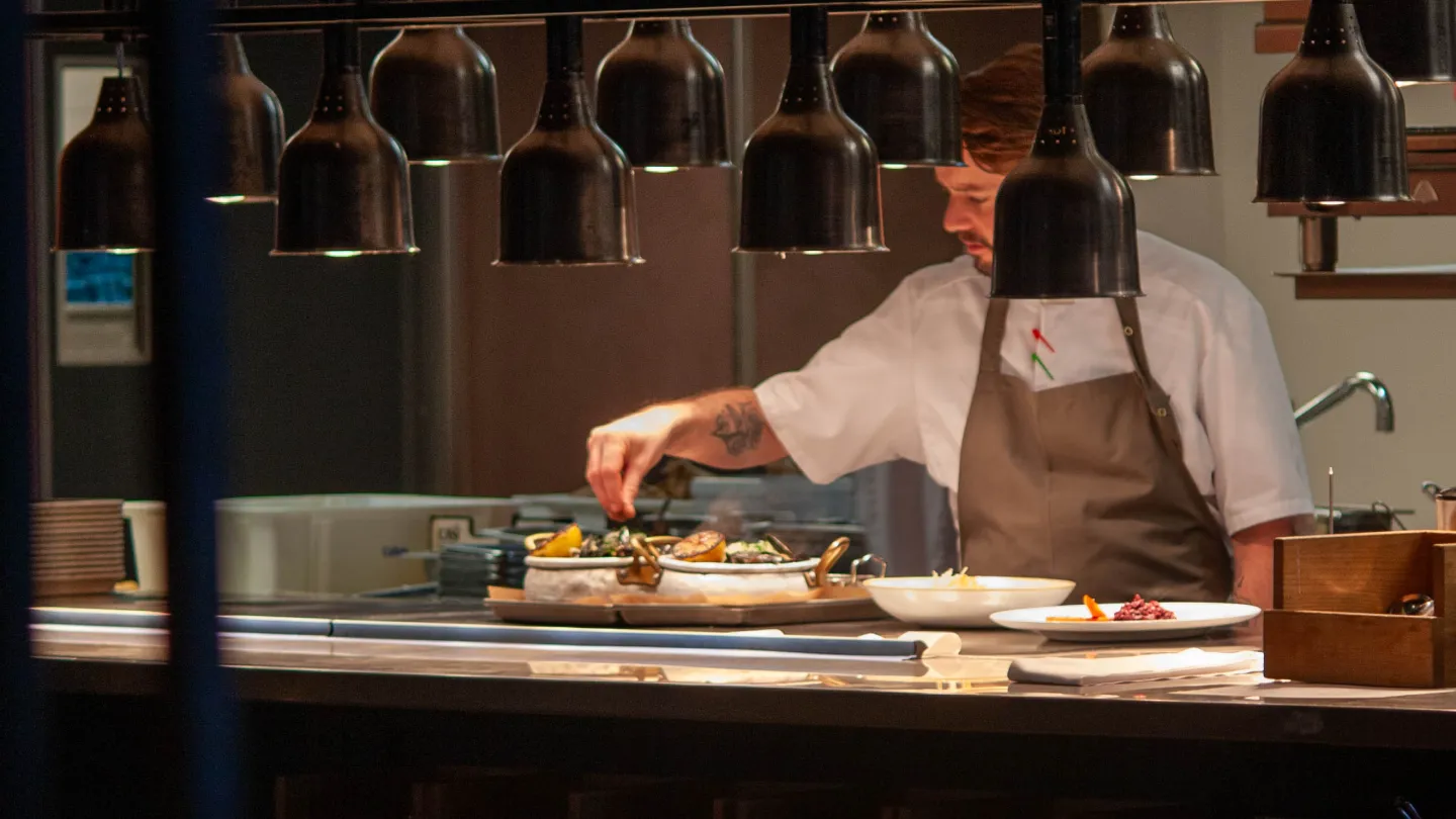 A chef preparing a dish at Grand Café
