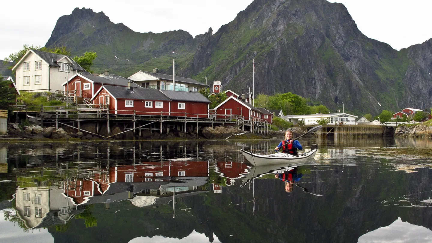 A person in a kayak outside of Svinøya Rorbuer