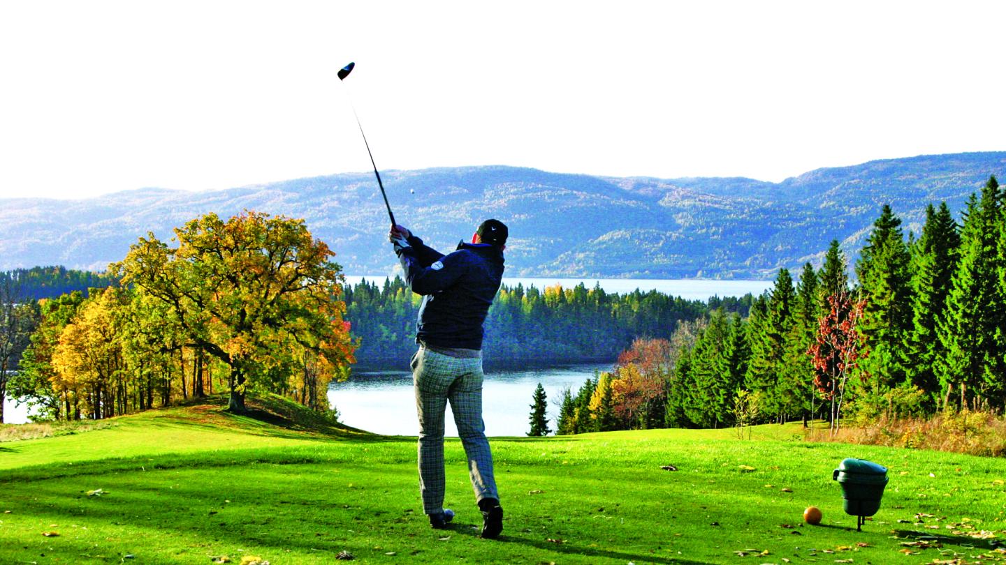 A golfer enjoying the course outside of Sundvolden Hotel