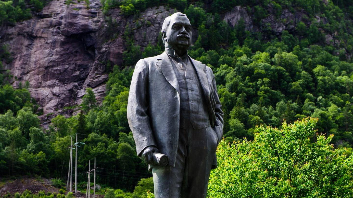 A statue in front of the majestic mountains outside of Rjukan Admini Hotel