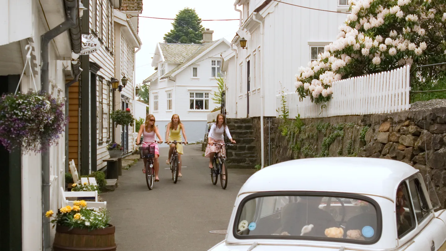 Three girls biking through the streets of Sogndalstrand