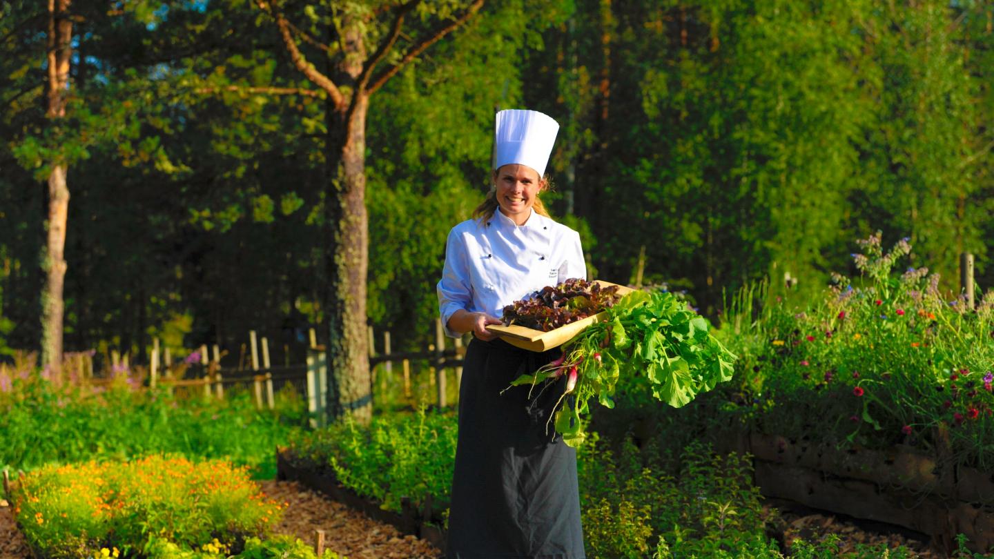 Solveig Storaas getting fresh produce from the garden at Søstrene Storaas
